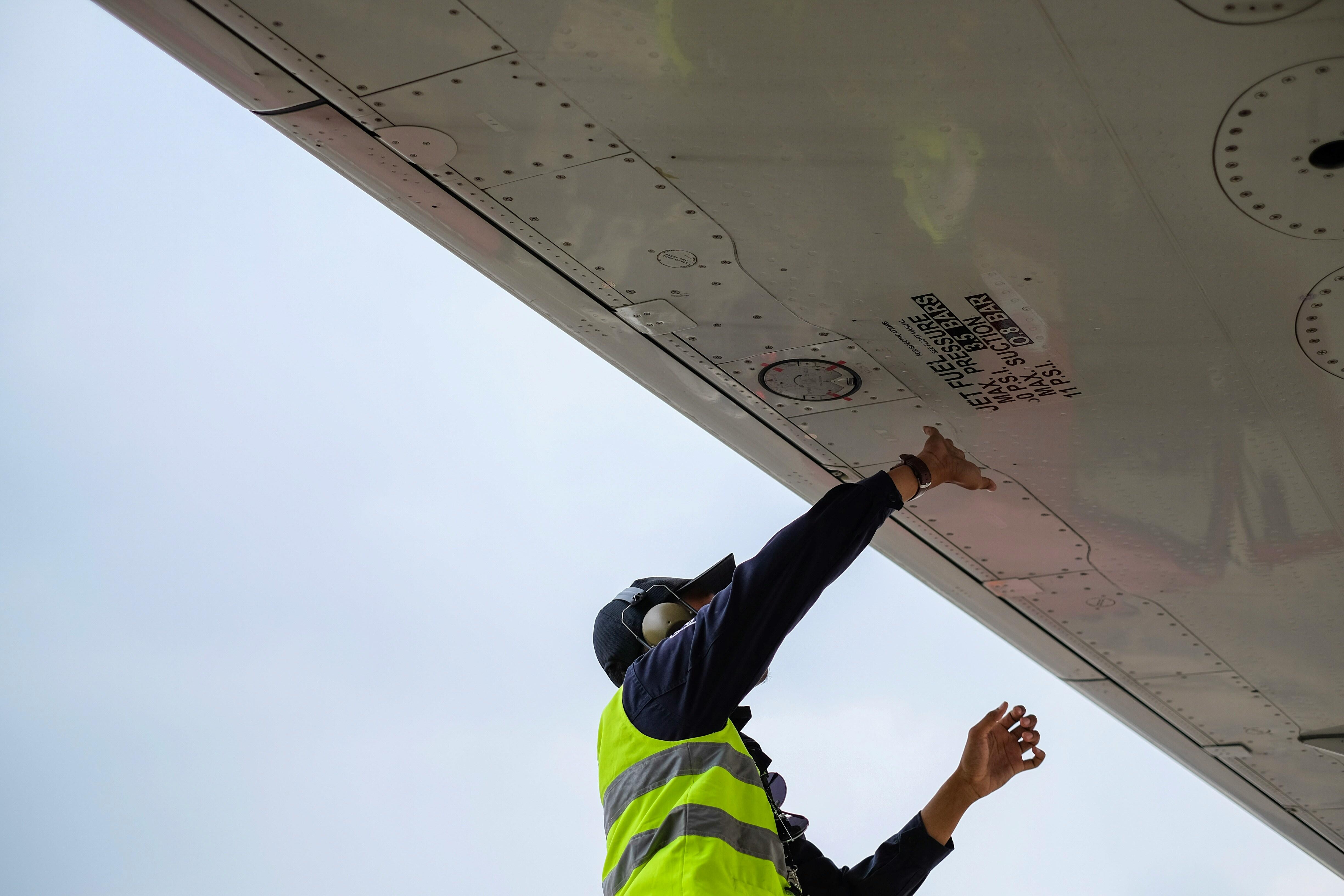 Person working on underside of airplane